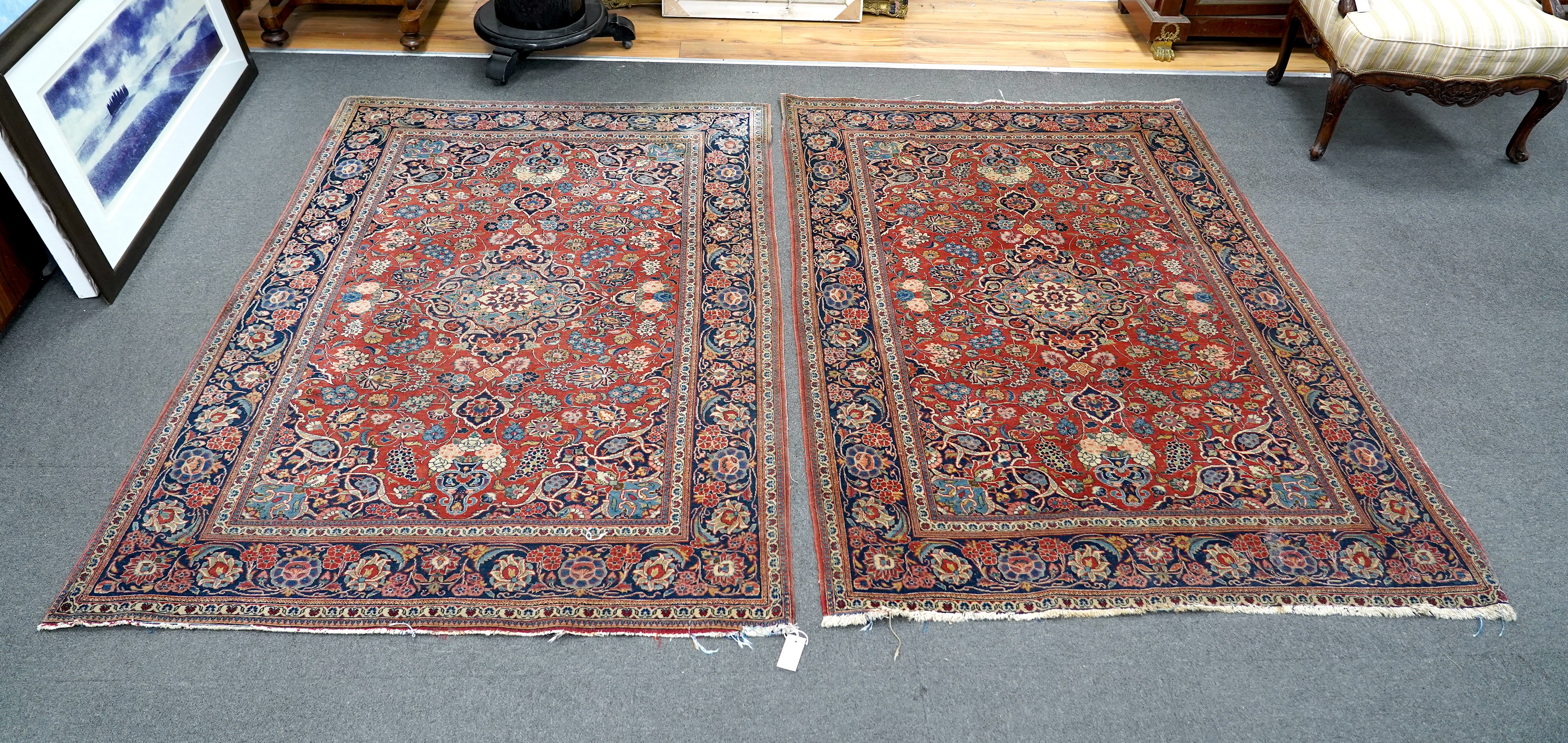 A pair of antique Tabriz brick red ground rugs, 200 x 136cm. Condition - fair